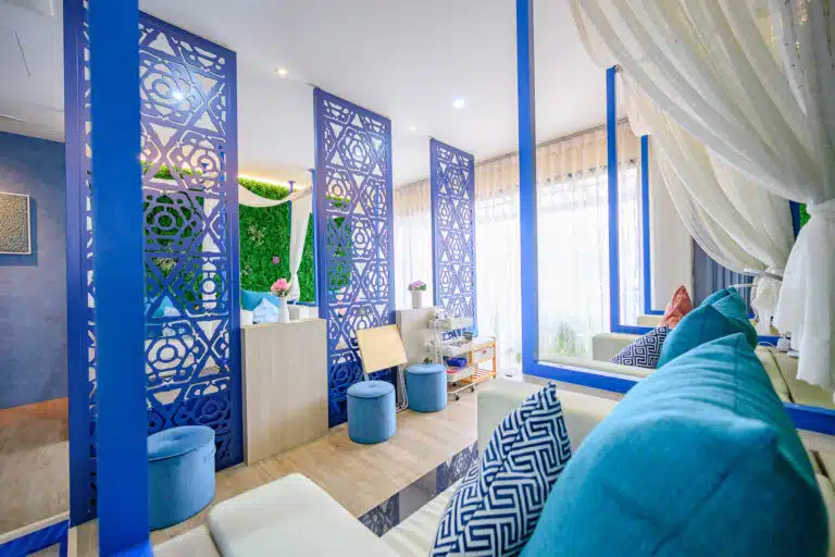 wellness spa treatments in laguna phuket: Inside view of Apsara Spa featuring vibrant blue decor, cosy seating, and a serene ambiance.
