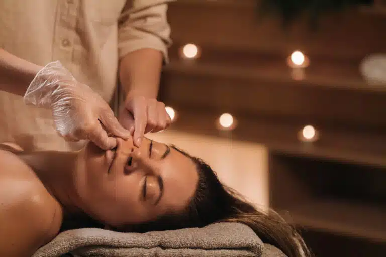 Seasonal spa treatments in Phuket: Facial and neck massage session in a serene spa setting with candles
